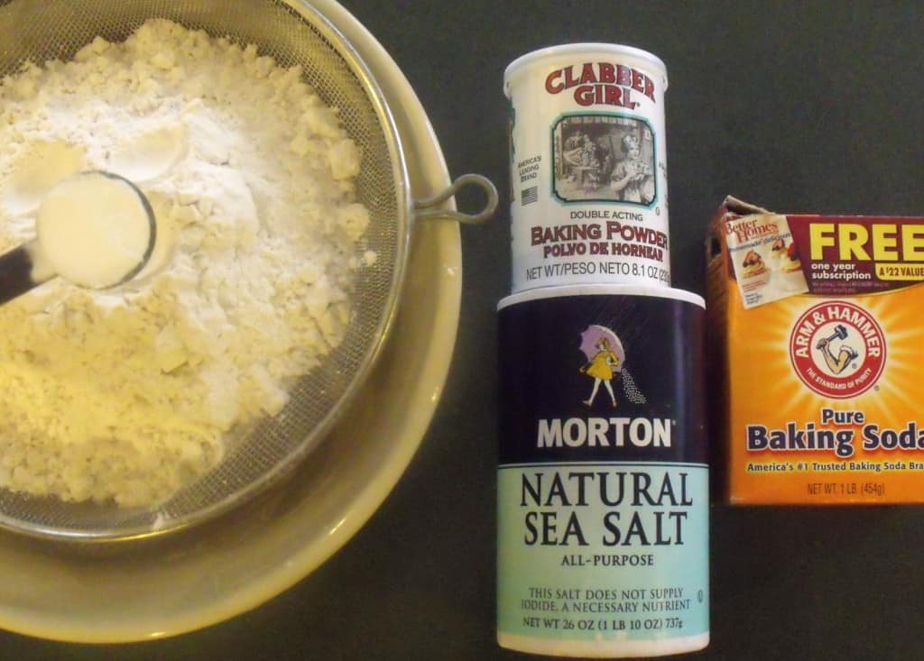 Sifting flour salt, baking powder and baking soda together