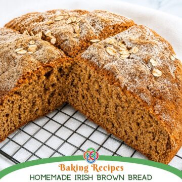 Freshly baked Irish brown bread loaf cut open to show a soft, hearty crumb, topped with oats and resting on a cooling rack over a white cloth.
