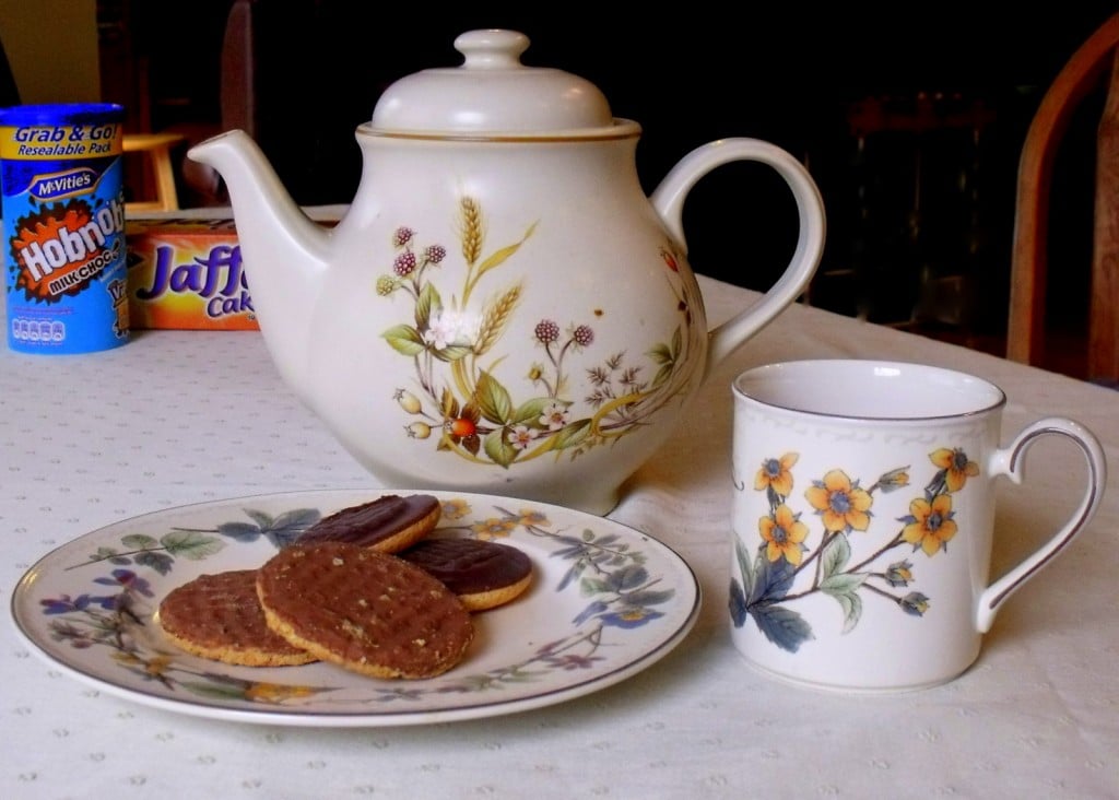 Cup of Tea and Biscuits | Irish American Mom A tea pot with a floral mug and a plate of biscuits