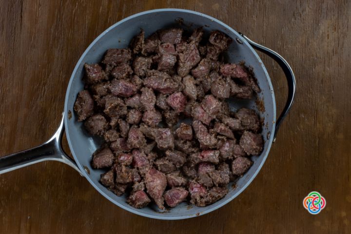 Browned flour dredged beef in a skillet for Irish Guinness beef stew | Irish American Mom Browned beef for stew in a skillet