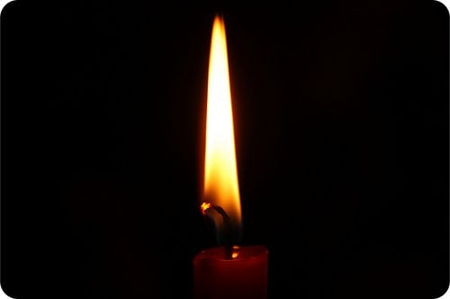 Christmas Candle | Irish American Mom A candle flame highlighted by a black background