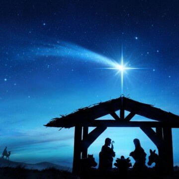 Night sky with a star over a silhouette of a stable nativity scene