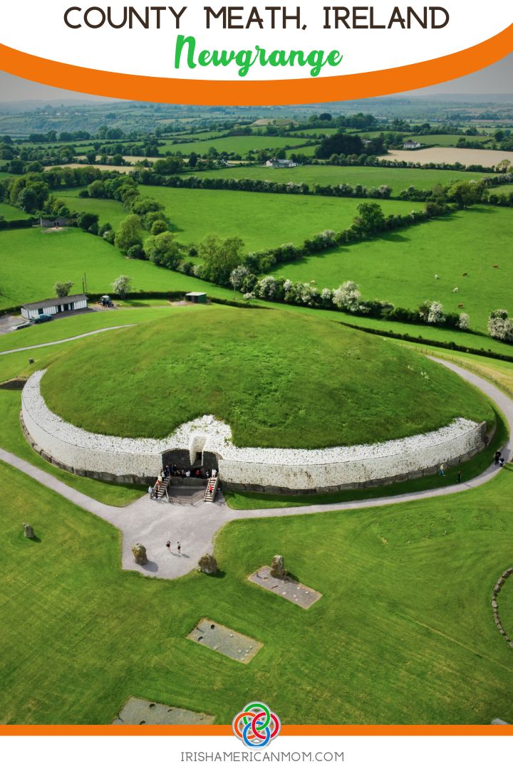 Aerial view of Newgrange passage tomb in County Meath, Ireland, showing the circular grassy mound, white quartz stone façade, entrance steps, and surrounding green countryside of the Boyne Valley.