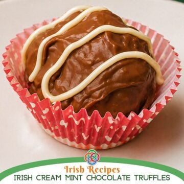 Close-up of a homemade Baileys chocolate truffle with white chocolate drizzle in a paper cup, labeled as Irish cream and mint chocolate truffles.