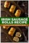 Golden flaky Irish sausage rolls on a wooden board, with one cut open showing the seasoned meat filling, styled on a rustic table with a cloth napkin.