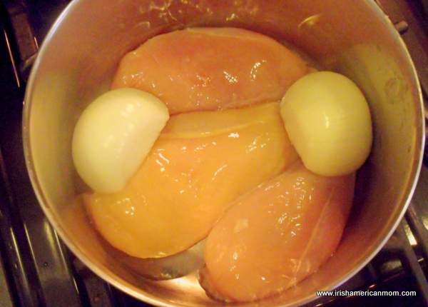 Three chicken breasts and onion in a pot for poaching | Irish American Mom Three chicken breasts and onion in a pot for poaching