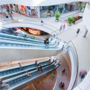 Looking down on two levels of escalators in a shopping mall