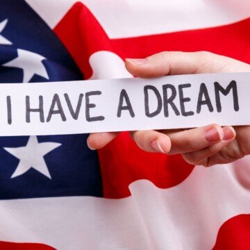 Text on a banner over an American flag