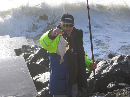 Fishing At Lahinch | Irish American Mom Man holding a fish and rod by the ocean