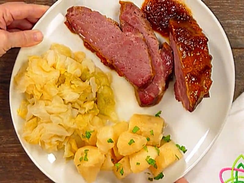 Apricot glazed corned beef brisket served with cabbage and boiled potatoes | Irish American Mom A white plate with a serving of apricot glazed corned beef, cabbage and boiled potatoes with parsley garnish