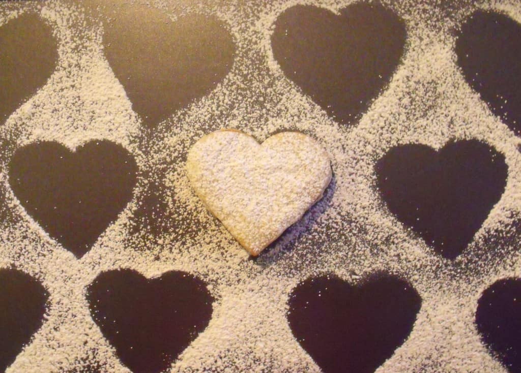 Cookie hearts on baking sheet Marks on a board where sugar was dusted over heart shaped cookies