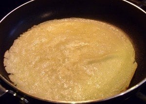 A crepe like pancake in a skillet before flipping