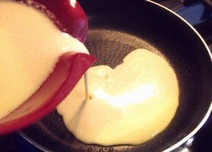 Pouring pancake batter into a hot skillet