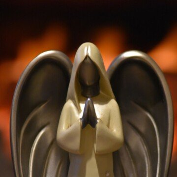 An angel statue with hands held together in prayer
