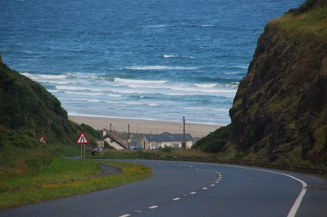Driving down a steep road to the beach at Downhill | Irish American Mom Road leading to a sandy beach