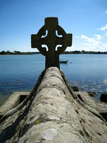 Celtic Cross in Brittany, France Celtic cross by a body of water