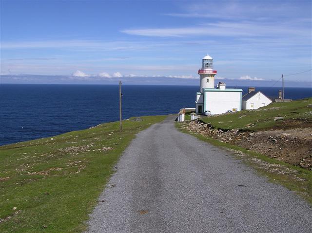 Lighthouse by a road beside the ocean
