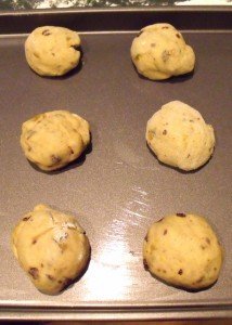 Dough balls on a baking tray for hot cross buns