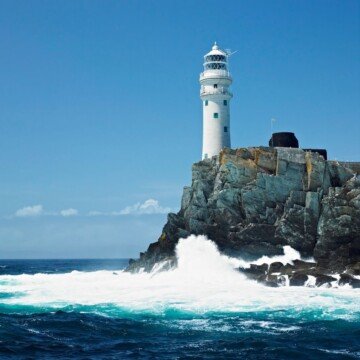 A lighthouse on a rocky island in the ocean