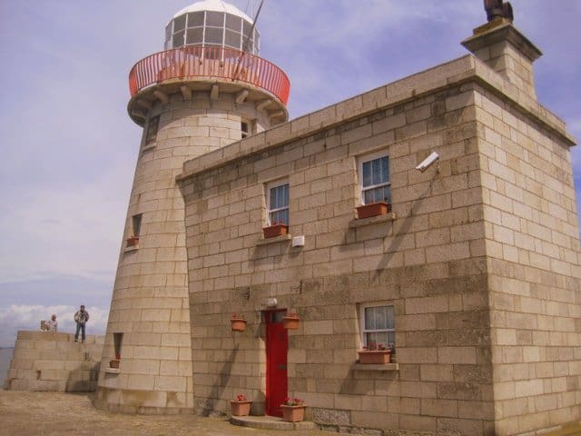 A red doored lighthouse on a pier