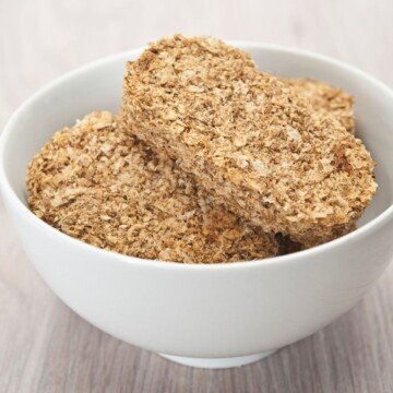 Three wholewheat cereal biscuits in a white bowl