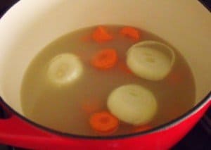Poaching turkey in stock in a pot