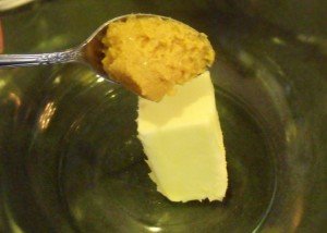 Adding butter and garlic puree to a bowl