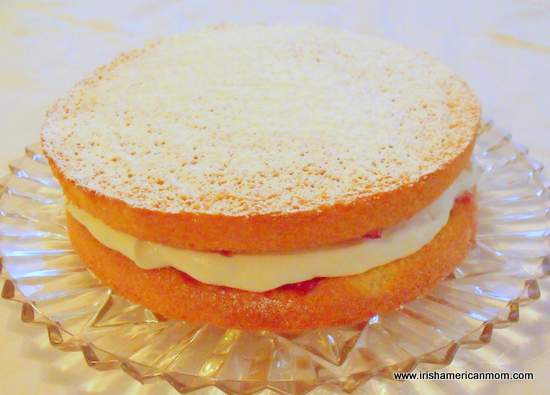 Mit Sahne und Marmelade gefüllter irischer Biskuitkuchen mit einem Abstauben von Konditor- oder Puderzucker's or icing sugar