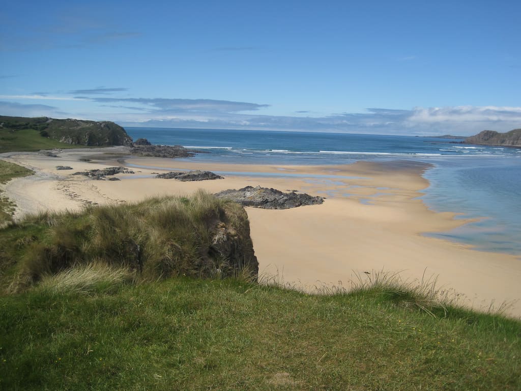 Doagh Strand, Co. Donegal | Irish American Mom A view of the Atlantic Ocean from grass covered sand dunes beside a sandy beach