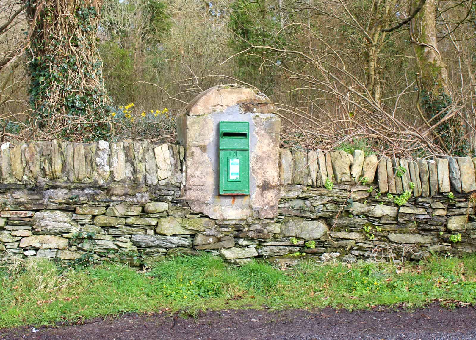 Green rural Irish post box in West Cork | Irish American Mom A green post or mail box on a stone wall in Ireland