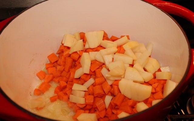Adding carrots and potato to soup | Irish American Mom Onions potato and carrots in a pot for carrot and coriander soup