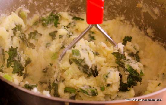 Mashing potato and kale for colcannon | Irish American Mom Mashing potato and kale for colcannon