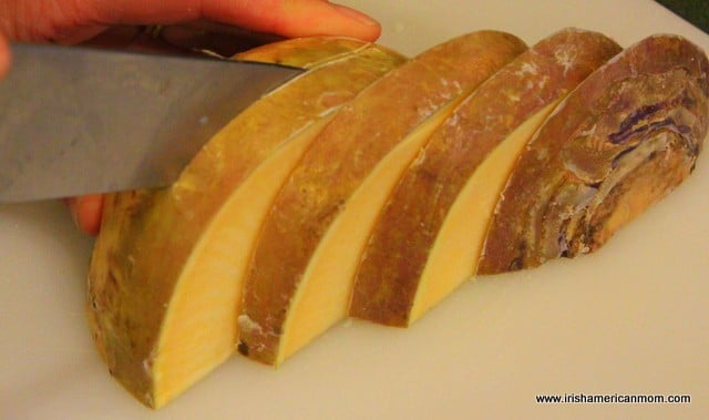 Slicing A Rutabaga on a chopping board | Irish American Mom Slicing A Rutabaga into semicircles with a knife