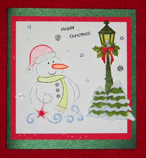 A silver embroidered snowman on a greeting card
