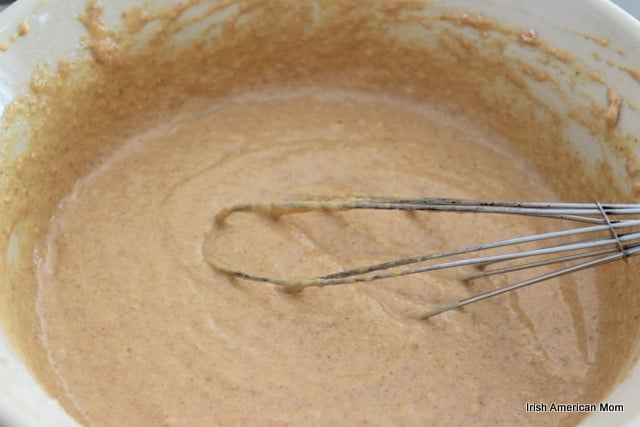 Whole Wheat Pumpkin Pancake Batter | Irish American Mom pumpkin pancake batter with a whisk in a bowl
