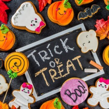 Text on a chalk board surrounded by Halloween cookies