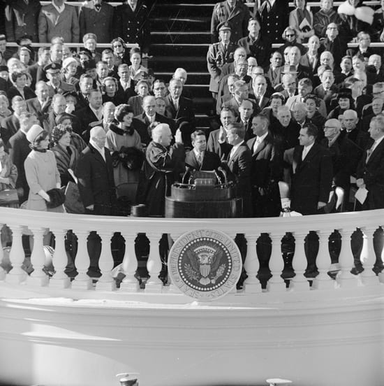 Inaguration of John F Kennedy as President | Irish American Mom A group of people standing on a balcony for an inauguration ceremony