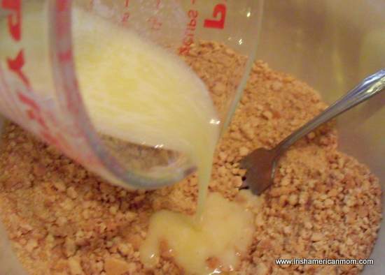 Pouring melted butter into graham cracker crumbs | Irish American Mom Pouring melted butter into graham cracker crumbs