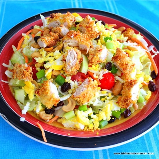 Chicken pieces on a greens salad | Irish American Mom chicken tender pieces over a salad of greens and tomatoes on a plate