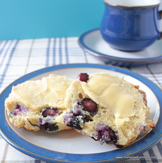 Buttered halves of a blueberry scone with a tea cup