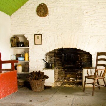 An open hearth with a chair and a bucket of turf