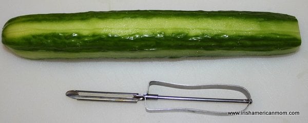 Peeling a cucumber in stripes for Shrimp and Cucumber Bites | Irish American Mom Peeling a cucumber in stripes