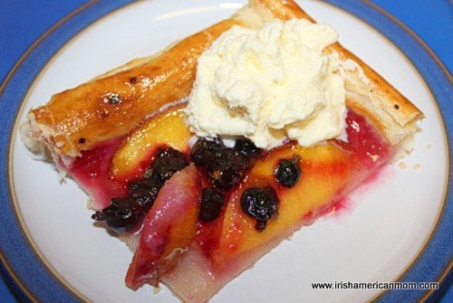 a square slice of nectarine and blackcurrant galette