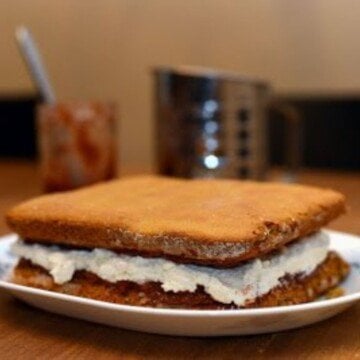A cream filled sponge cake on a white plate
