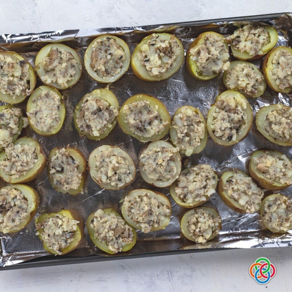 Stuffed potato appetizers on a baking pan before cookingappetizer | Irish American Mom Stuffed potato halves on a baking tray