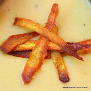 Garnishing a bowl of parsnip soup with parsnip chips
