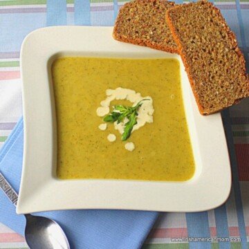 Soup in a square bowl with two slices of bread balanced on the edge