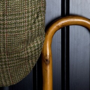 A tweed cap beside a wooden cane