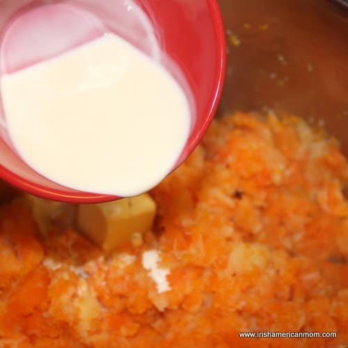 Adding butter and cream to carrot and parsnip mash. | Irish American Mom Adding butter and cream to carrot and parsnip mash.