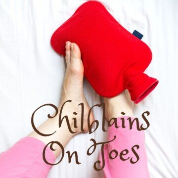 Feet holding a red hot water bottle with text overlay
